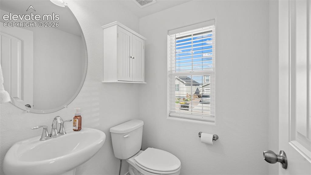 Image 14 of 38: White pedestal sink with a chrome-finish faucet