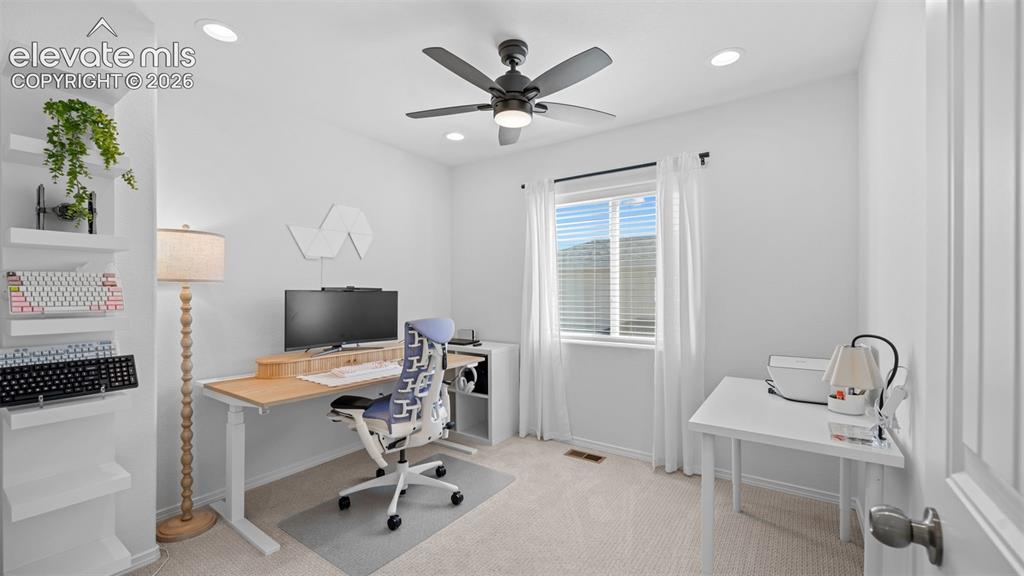 Image 17 of 38: Brightly lit room featuring a window with blinds, recessed ceiling lighting