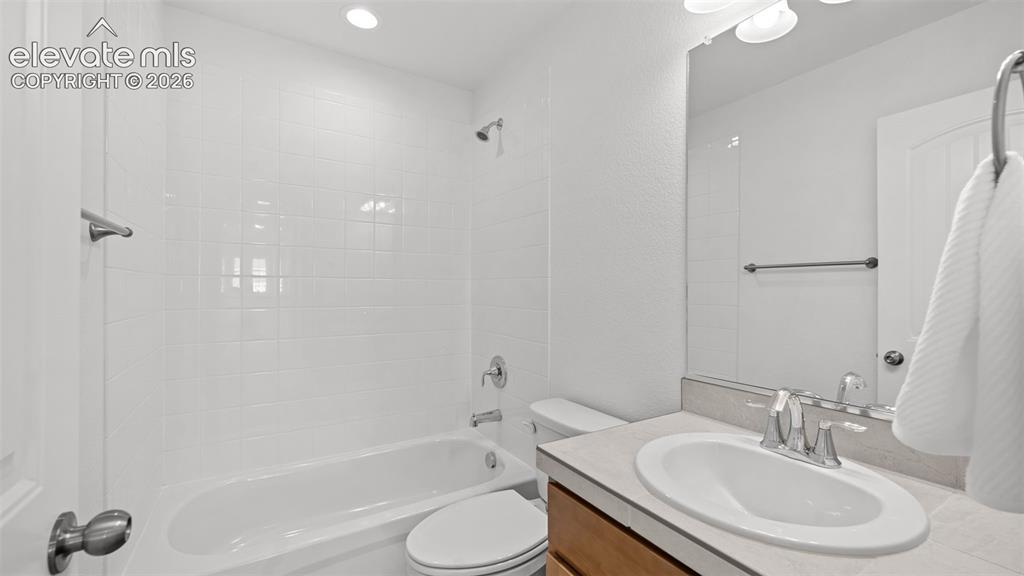 Image 19 of 38: Bathroom featuring a white ceramic tile shower surround, integrated bathtub