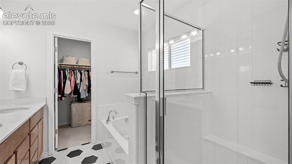 Image 22 of 38: Spacious bathroom featuring a glass-enclosed shower, built-in bathtub, wood
