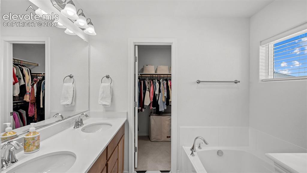Image 23 of 38: Dual vanity with undermount sinks, chrome fixtures, and a white countertop