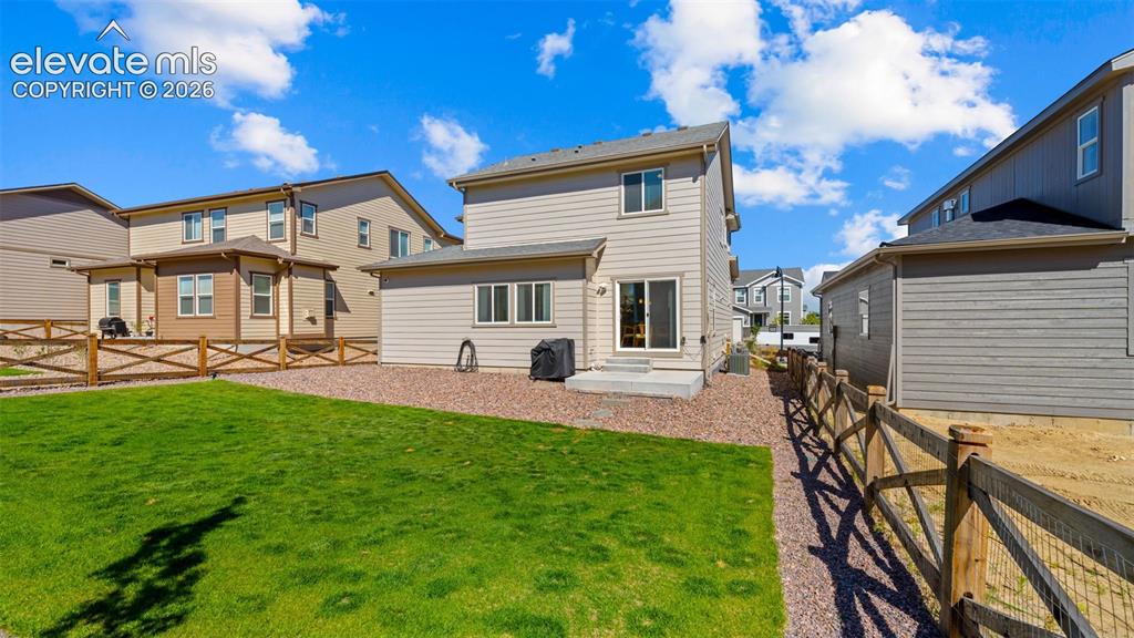 Image 26 of 38: Expansive backyard featuring a manicured lawn area, a gravel perimeter, and