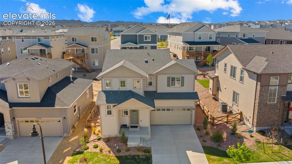 Image 29 of 38: Two-story residence featuring a neutral-toned exterior with stone accents a
