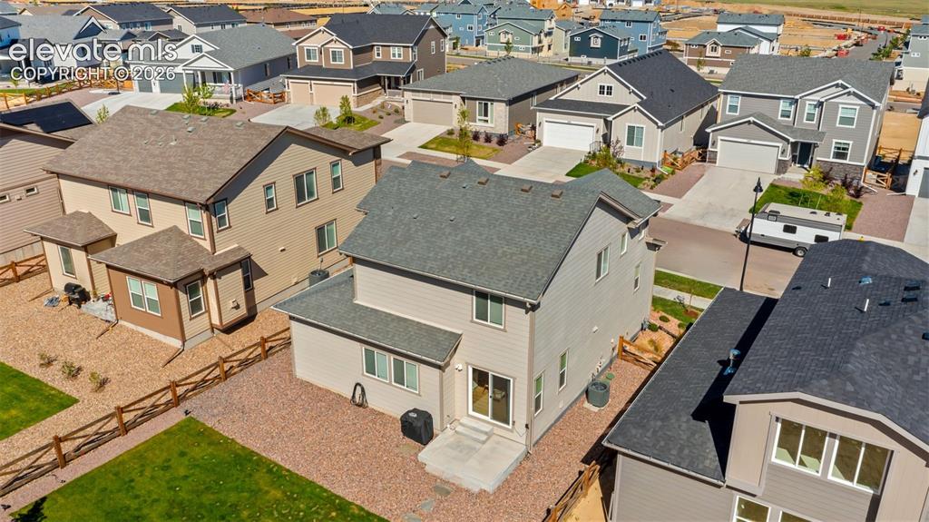 Image 33 of 38: Two-story residence featuring light-colored siding and a dark shingle roof