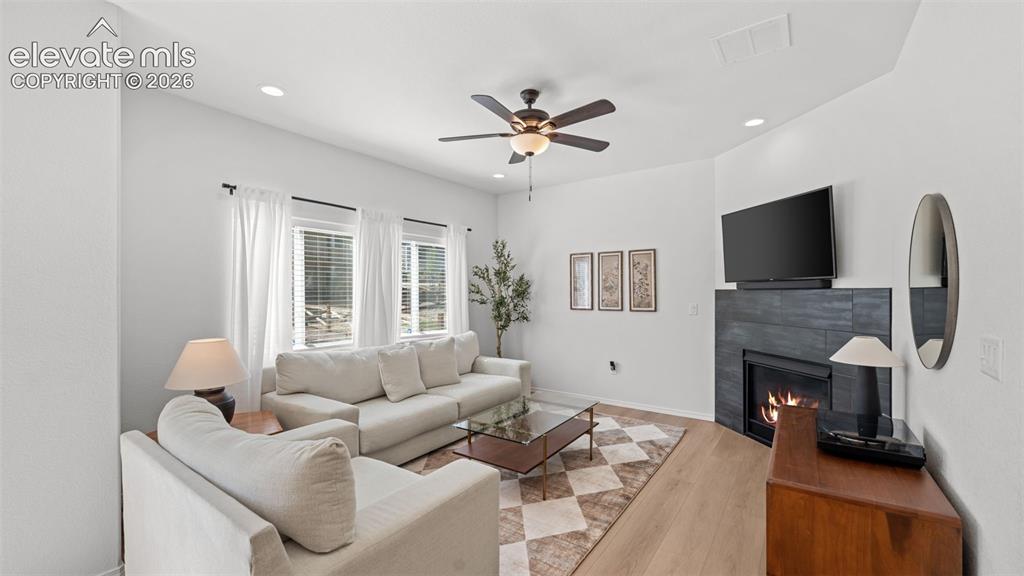 Image 9 of 38: Living area with light wood-finish flooring, white walls, and recessed ligh