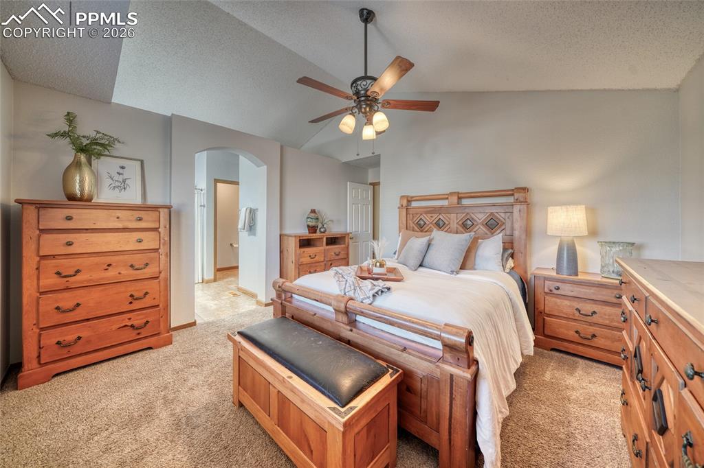 Image 19 of 46: Bedroom featuring ensuite bath, arched walkways, light colored carpet, and 