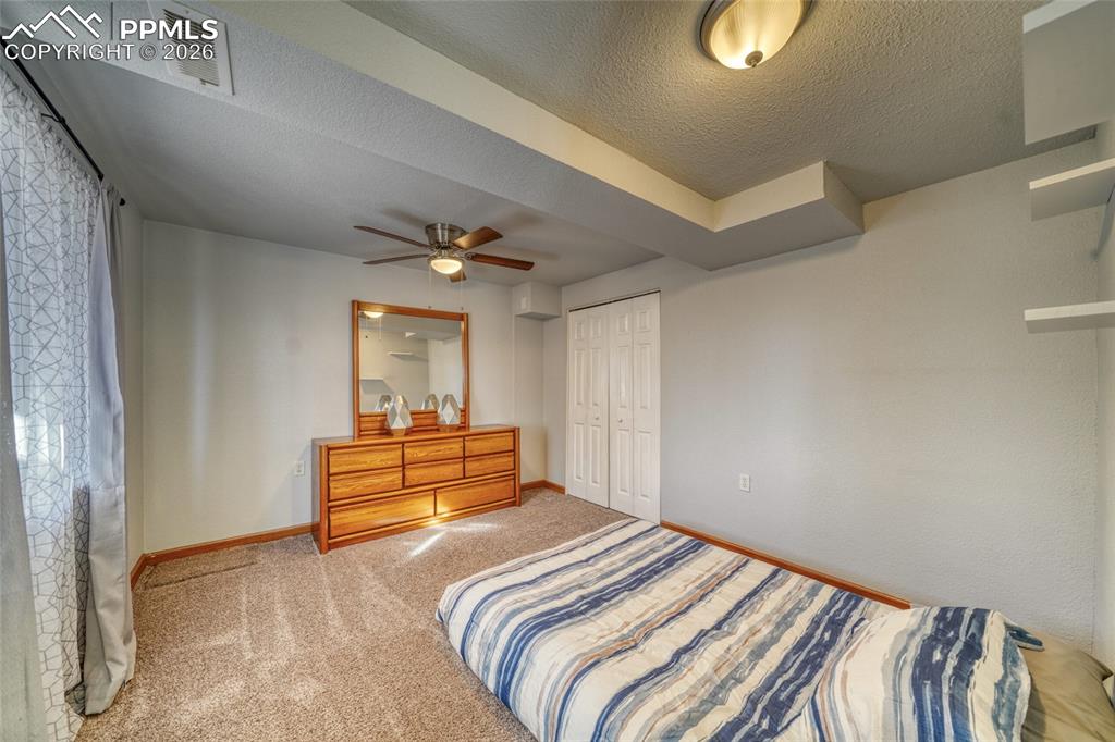 Image 30 of 46: Carpeted bedroom featuring a textured ceiling, a closet, and a ceiling fan