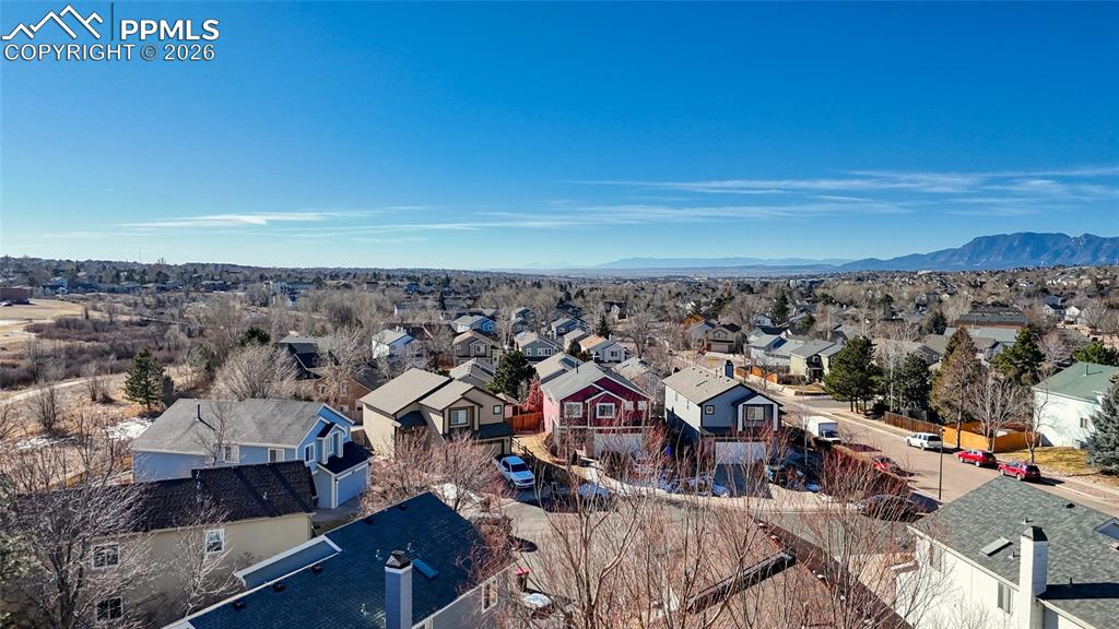 Image 44 of 46: Aerial perspective of suburban area featuring a mountainous background