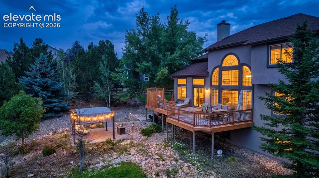 Image 1 of 50: Multi-level backyard and wood-deck with dark railings, expansive arched win