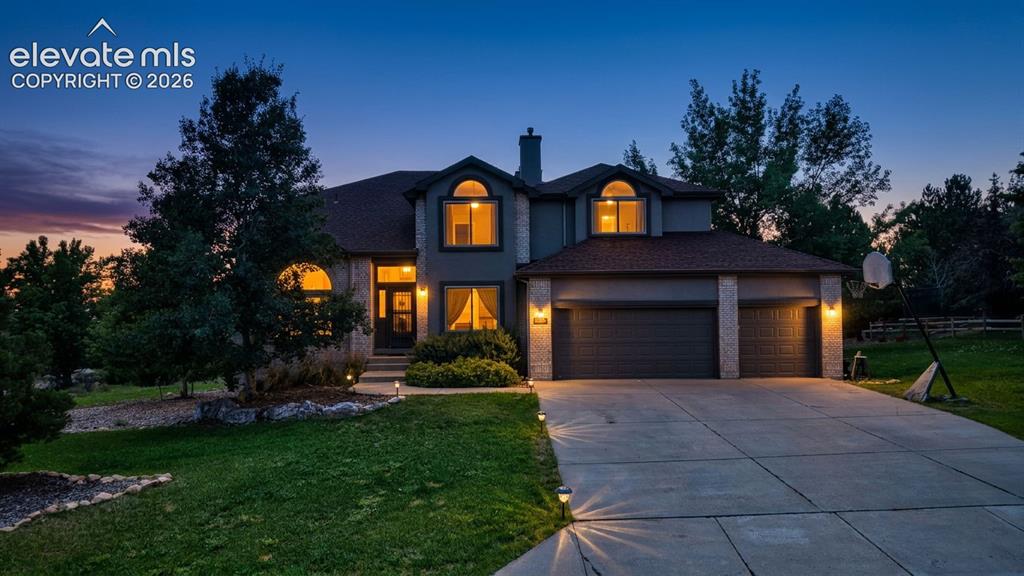 Image 2 of 50: Two-story residence featuring a stone and stucco exterior, arched windows, 