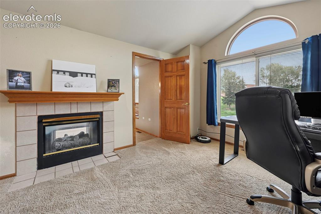 Image 24 of 50: Fireplace with a tile surround and wood mantel