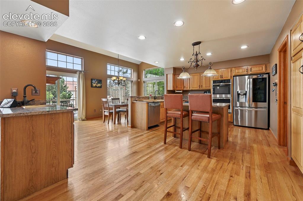Image 3 of 50: Kitchen featuring wood cabinetry, stainless steel appliances, a center isla