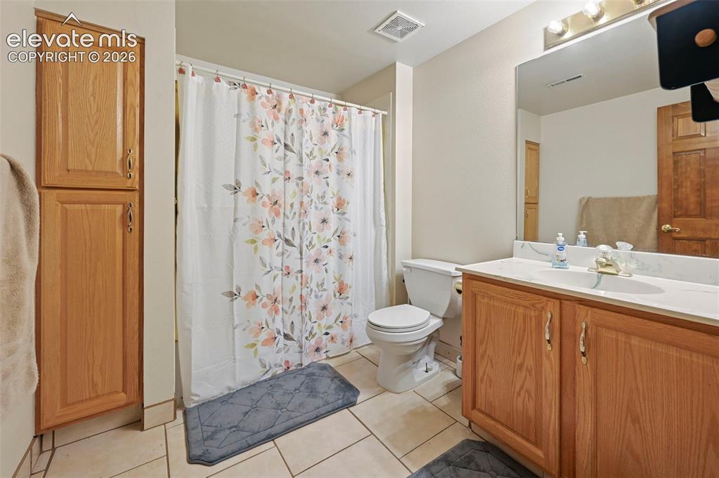 Image 35 of 50: Basement bathroom featuring a vanity with wood cabinetry, a white counterto