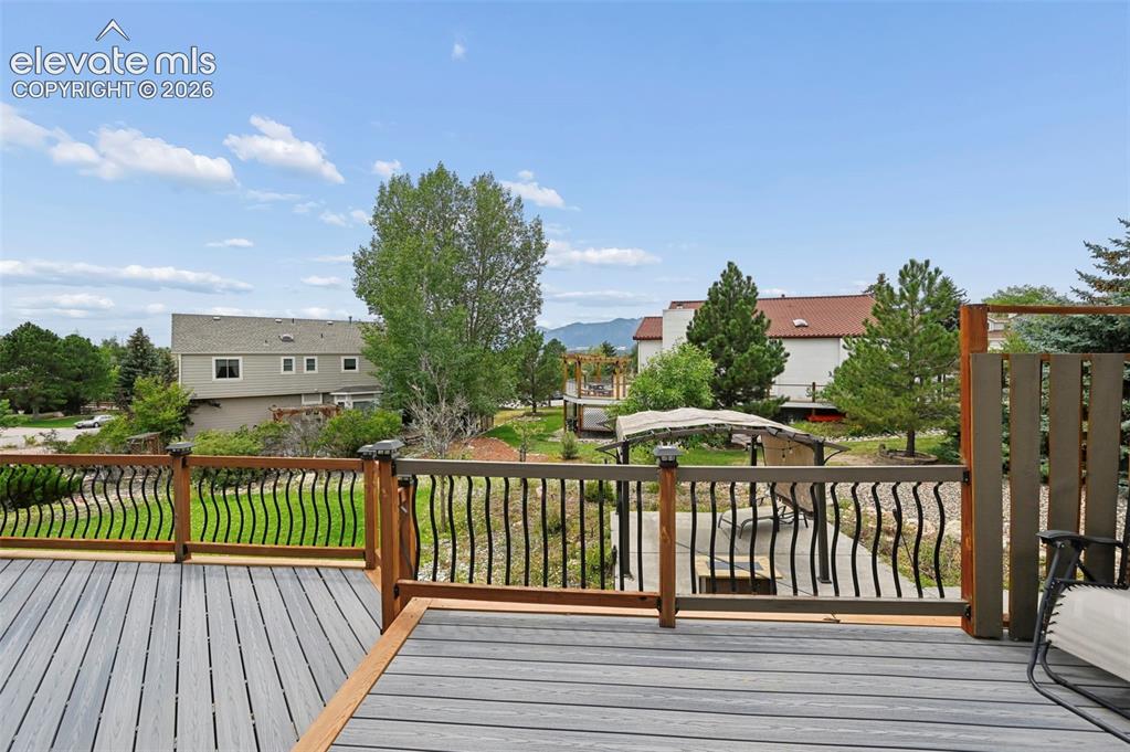 Image 37 of 50: Expansive composite deck featuring wood-finish railings with decorative bla