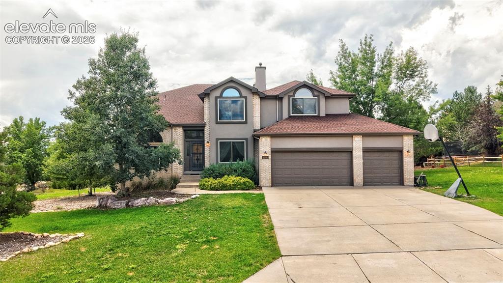 Image 39 of 50: Two-story residence featuring a three-car garage, a concrete driveway, and 