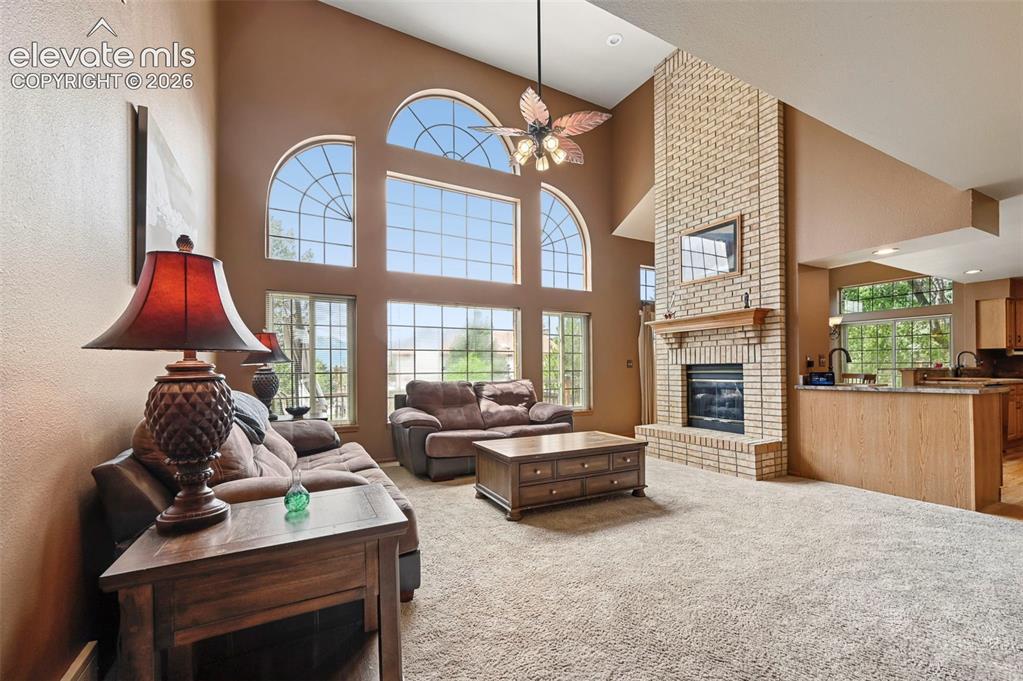 Image 4 of 50: Vaulted ceiling family room with a floor-to-ceiling brick fireplace, an int