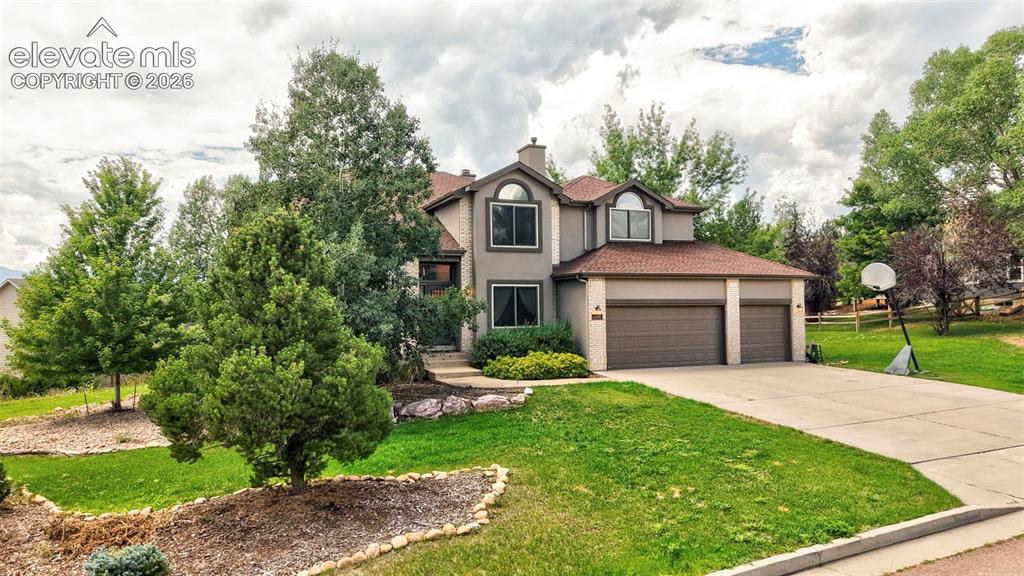 Image 41 of 50: Two-story residence with a three-car garage, concrete driveway, and a front