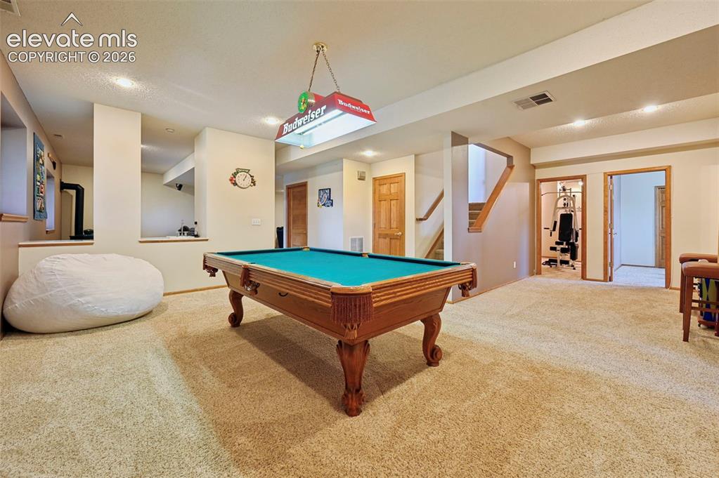 Image 5 of 50: Basement game area with recessed lighting, open doorways, and an exposed wo