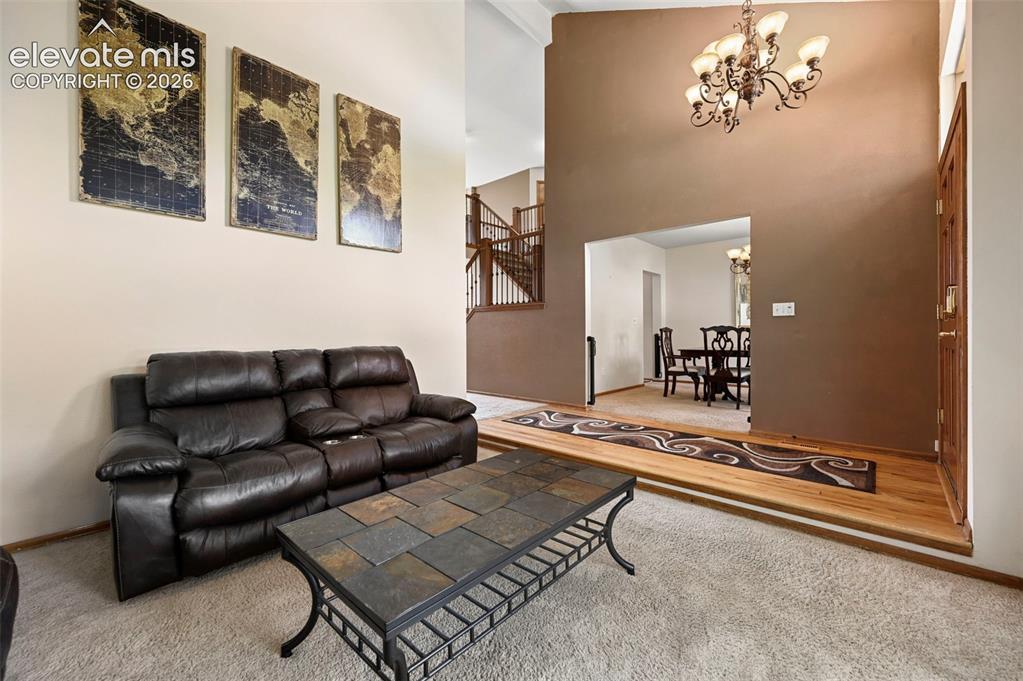 Image 6 of 50: Two-story foyer with a decorative chandelier, and an entry to a formal dini