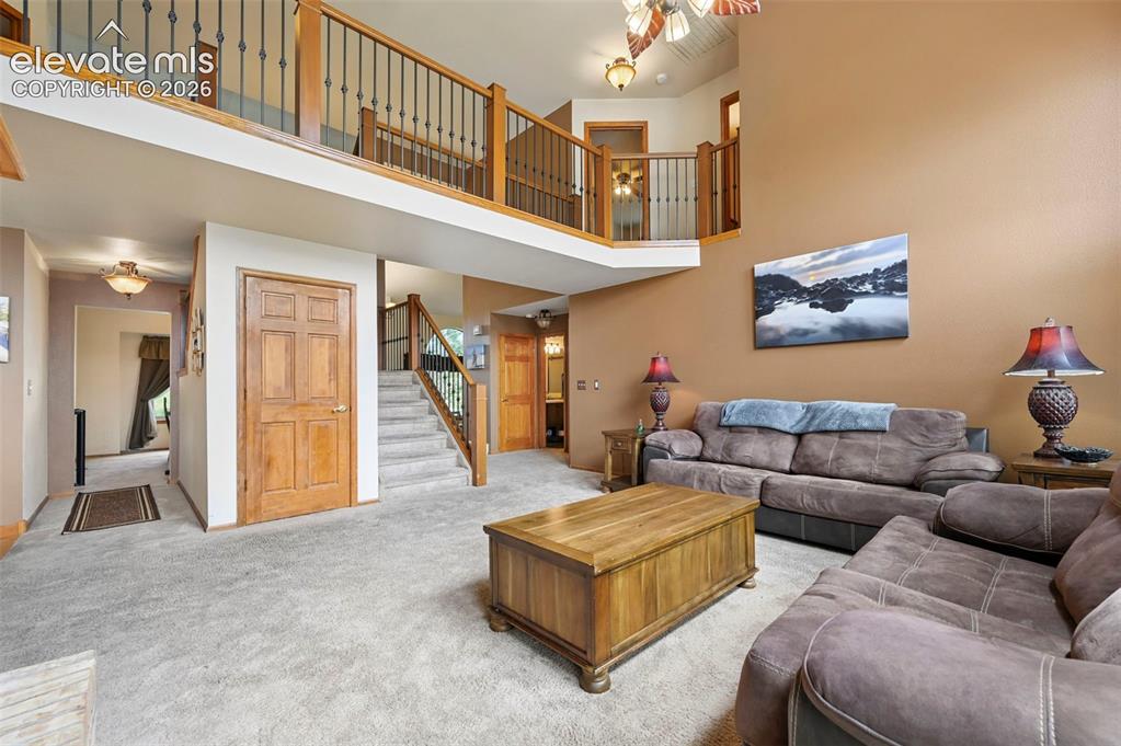 Image 9 of 50: Two-story family room with high ceilings, arched transom windows, and an up