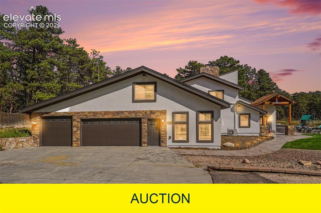 Image 1 of 50: Stucco exterior with stone accents, attached three-car garage, covered entr