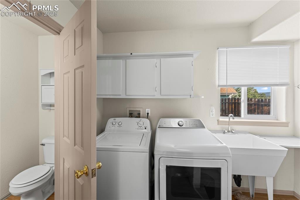 Image 12 of 38: Laundry area with washer and dryer and baseboards