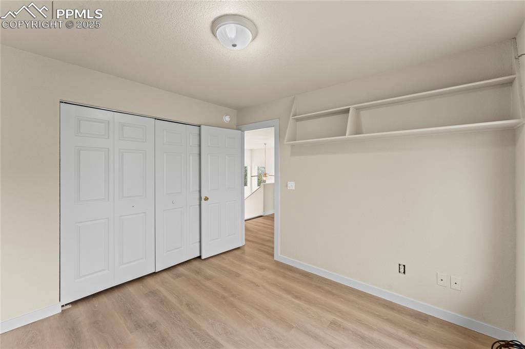 Image 21 of 38: Unfurnished bedroom featuring light wood finished floors, a closet, and a t