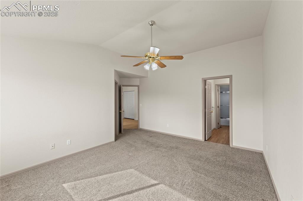 Image 23 of 38: Unfurnished bedroom featuring vaulted ceiling, carpet, a ceiling fan, and c