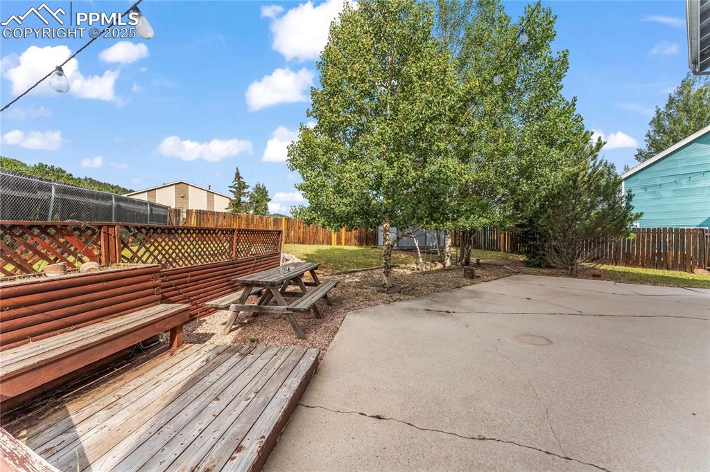 Image 28 of 38: Fenced backyard with a patio area