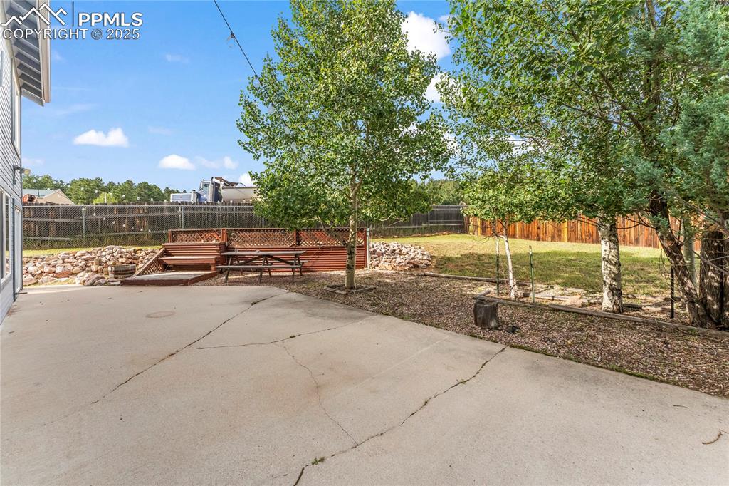 Image 29 of 38: Fenced backyard with a patio