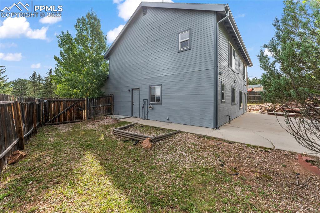 Image 31 of 38: Rear view of house featuring a fenced backyard and a patio