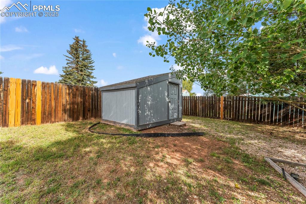 Image 32 of 38: Fenced backyard featuring a shed
