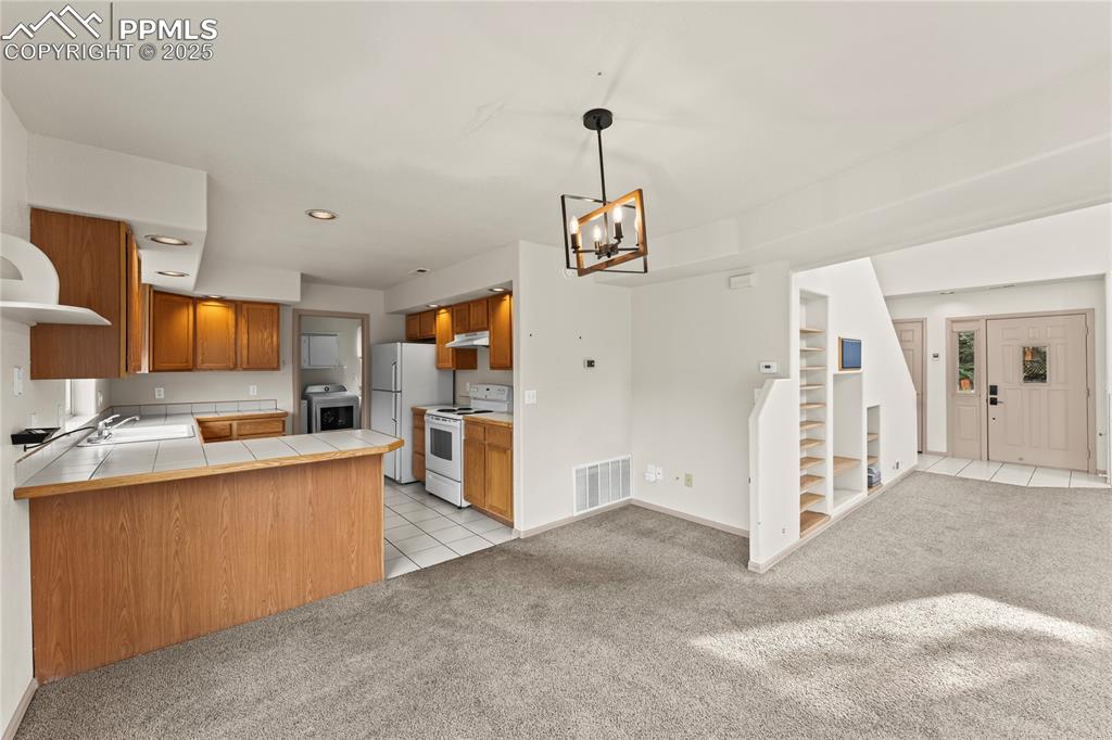 Image 7 of 38: Kitchen featuring tile counters, light tile patterned floors, light colored