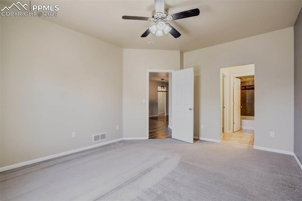 Image 18 of 47: Unfurnished bedroom with visible vents, baseboards, ensuite bath, and light