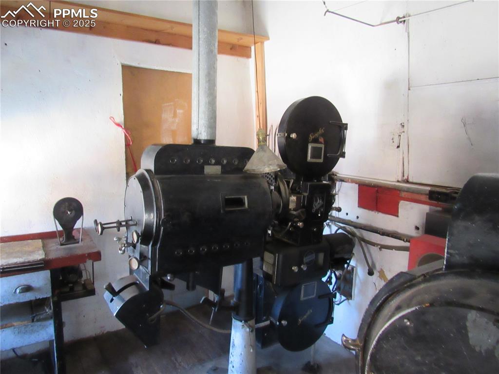 Image 10 of 17: Miscellaneous room with a wood stove and wood finished floors