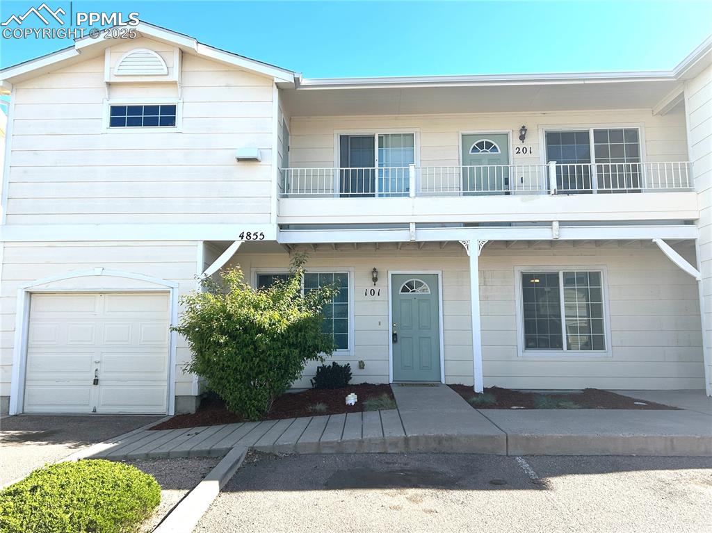 Caption: Townhome / multi-family property featuring an attached garage and a balcony