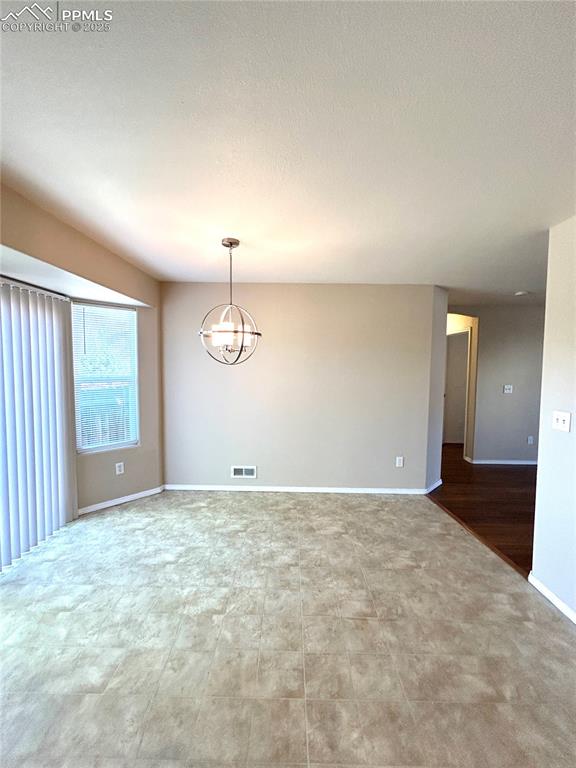 Image 14 of 43: Empty room featuring baseboards, visible vents, a textured ceiling, and a n