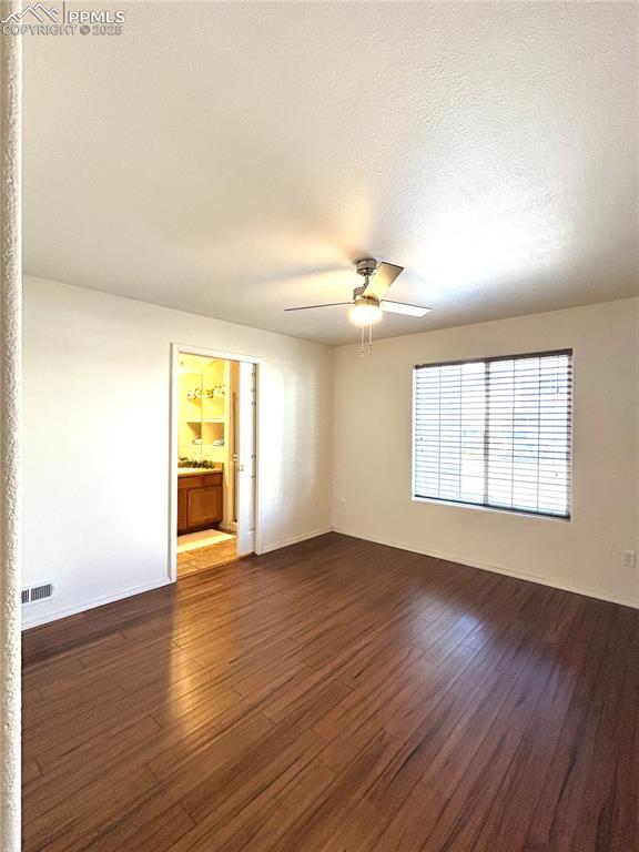 Image 16 of 43: Master bedroom room featuring ceiling fan, dark wood-style flooring,