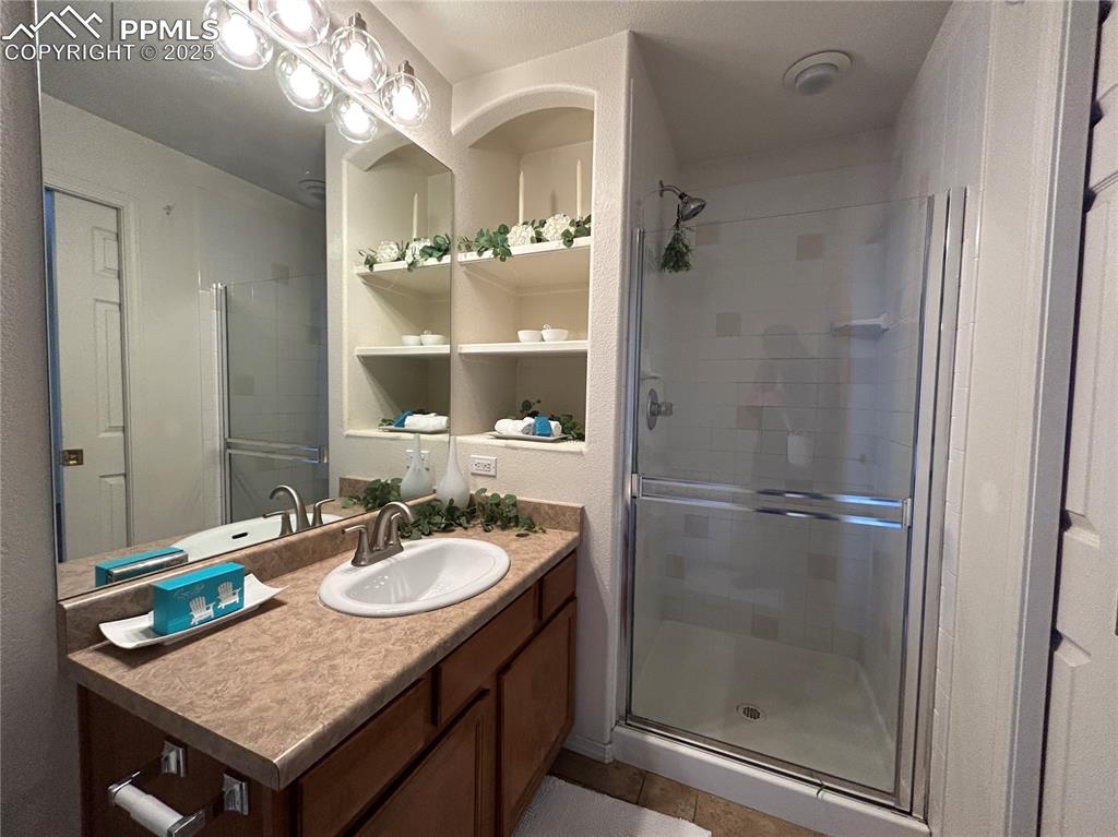 Image 19 of 43: Full bathroom with vanity, tile patterned flooring, and a shower stall
