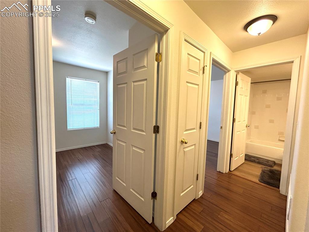 Image 21 of 43: Corridor with baseboards and dark wood finished floors