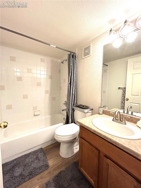 Image 27 of 43: Bathroom with visible vents, shower / bath combo with shower curtain, wood 