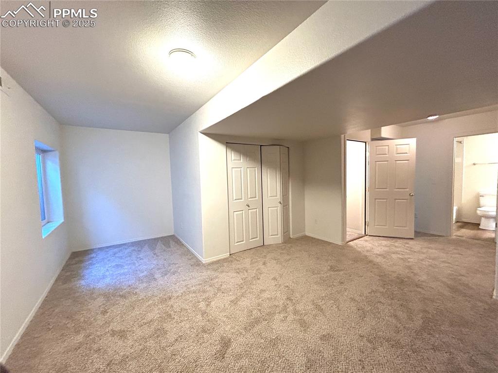 Image 31 of 43: Below grade area with baseboards, a textured ceiling, and carpet