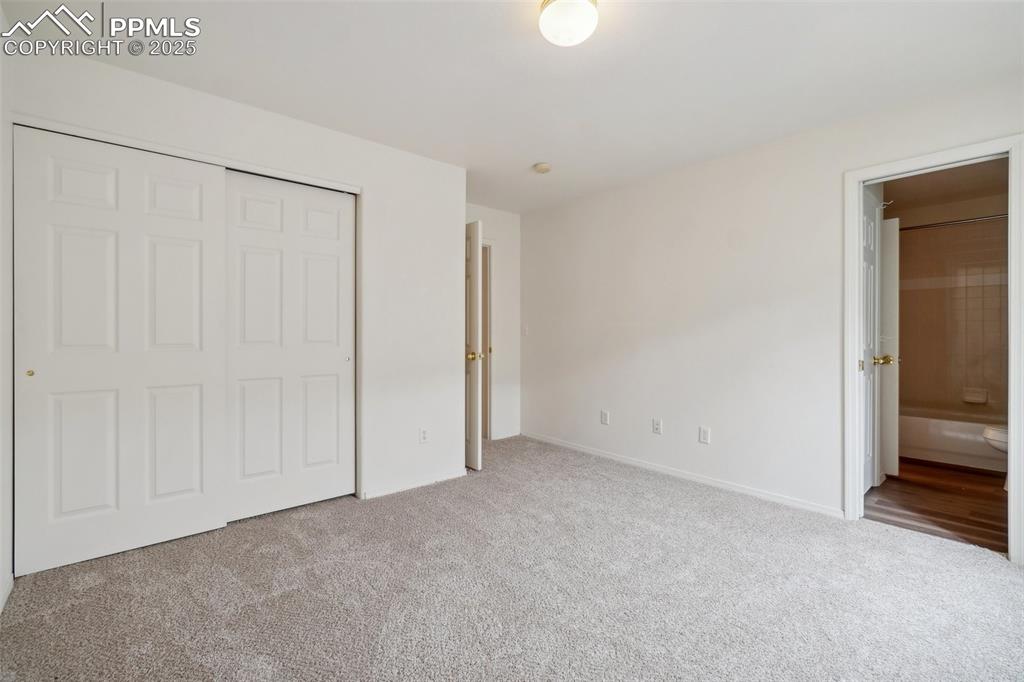 Image 35 of 43: Unfurnished bedroom featuring a closet, baseboards, ensuite bathroom, and c