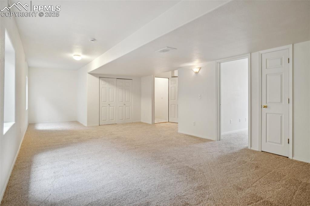 Image 36 of 43: Basement featuring baseboards and light carpet