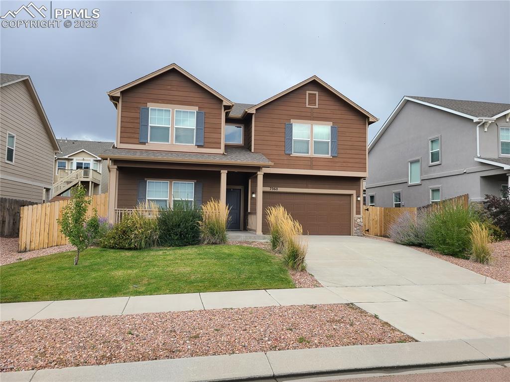 Caption: View of front of property with concrete driveway, an attached garage, and stone siding