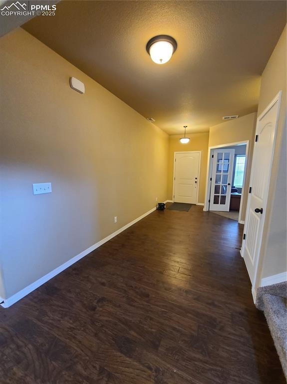 Image 12 of 29: Hallway featuring dark wood-type flooring and a textured ceiling