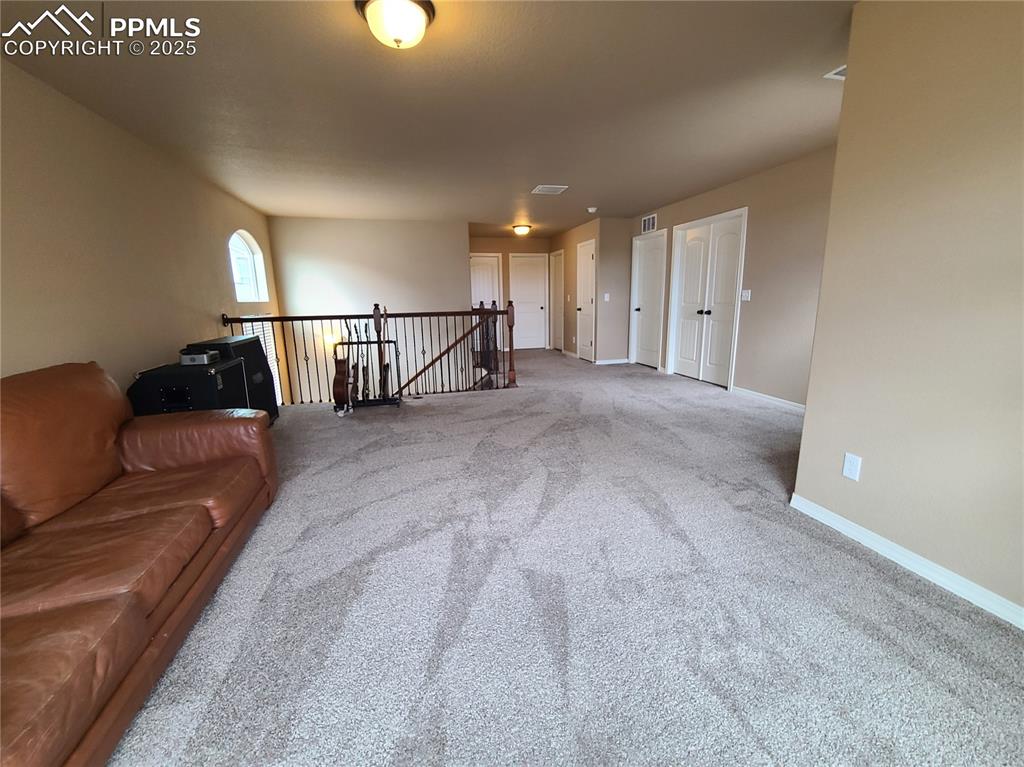 Image 14 of 29: Living room with carpet and baseboards