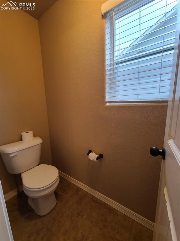 Image 20 of 29: Bathroom with toilet and dark tile patterned floors