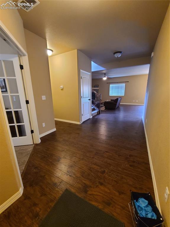 Image 4 of 29: Hall with dark wood-style flooring and stairway