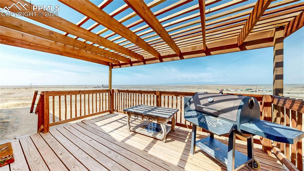 Image 31 of 40: Wooden deck with a grill and view of water and beach
